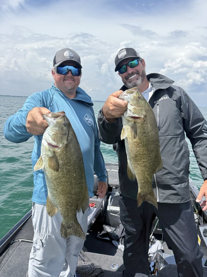 Two anglers showing their catches