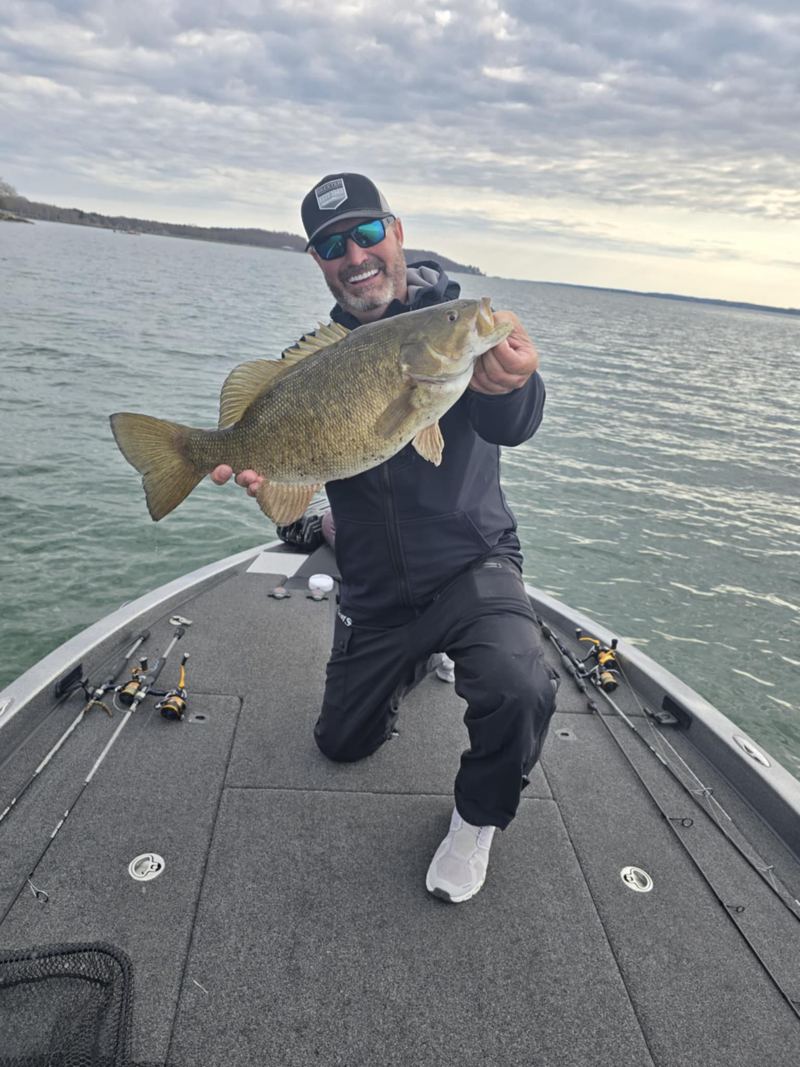 Brad holding fish aboard a boat
